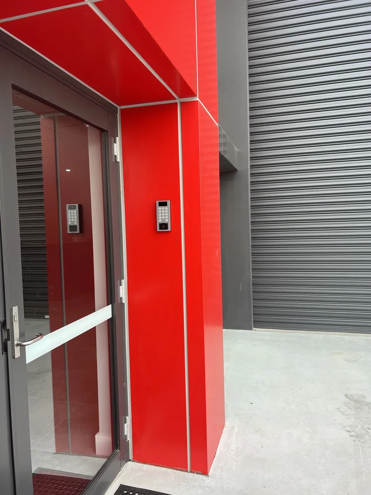 Netlink access-control keypad integration on a red retail counter — Newcastle & Hunter commercial fit-out access control and intercom install
